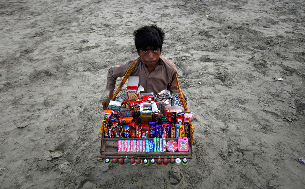 13χρονο αγόρι πουλάει μπισκότα και γλυκά σε παραλία του Πακιστάν.