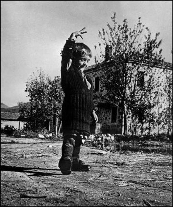 "Όταν είδα αυτή τη  φωτογραφία του 1947 
το πρώτο που σκέφτηκα είναι ότι το κοριτσάκι 
έχει στα χέρια του όλη του ζωή και είναι ευτυχισμένο. 
Το κοριτσάκι βρέθηκε από την αποστολή της Unicef, 
στο χωριό Οχιά Λακωνίας,
 κατά την περίοδο του εμφυλίου. 
Εκείνη και η γιαγιά της ήταν οι μόνοι κάτοικοι
 του χωριού που επέζησαν. 
Οταν πήρε τα μεγάλα αγορίστικα παπούτσια
 που βρέθηκαν πανηγύριζε για ώρες. 
Το όνομά της μικρής, Ελευθερία."